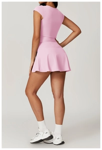 Detailed view of pink two-piece yoga set with compression top and athletic skirt