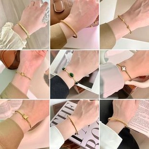 Gros plan de colliers en titane doré avec trèfle, perles et motifs de nœuds pour femmes
