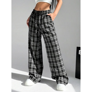 Detailed view of women's black and white plaid wide-leg trousers on a fashion model
