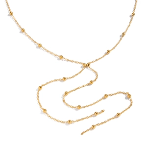 Gros plan détaillé d'un collier chaîne à billes dorées sur un fond blanc neutre