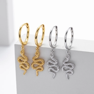 Detailed macro view of S925 sterling silver snake earrings in gold and silver finish