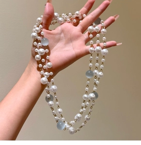 Detailed close-up of Baroque vintage layered pearl and blue opal cat eye beaded necklace