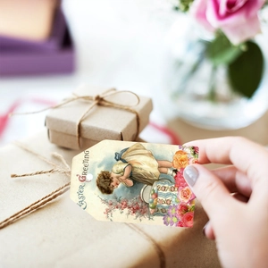 Close-up of vintage Easter gift tag with 'Easter Greeting' text held in hand for decoration