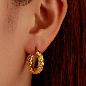 Polished 18K gold-plated twisted hoop earrings for women on a model closeup