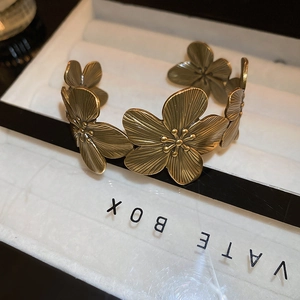 Macro shot of vintage gold flower cuff bracelet with detailed petal textures on display