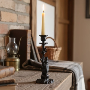 Bougeoir vintage en fonte noire avec sculpture humaine et une longue bougie beige