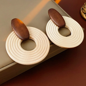 Vue détaillée des boucles d'oreilles géométriques en bois avec design bicolore