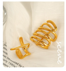 Macro shot of 18k gold plated wave ear cuff with polished finish on white fabric