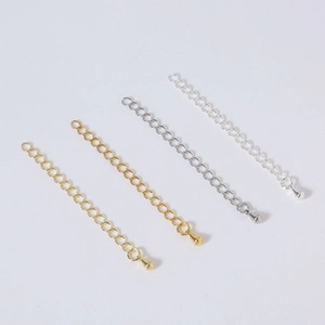 Detail view of gold and silver jewelry extension chains with water drop charms