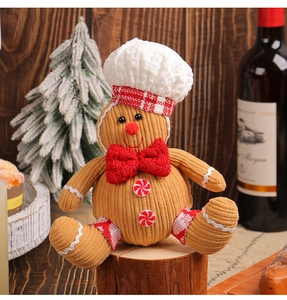 Close-up of a gingerbread man plush toy in corduroy with a chef hat and red bow decoration