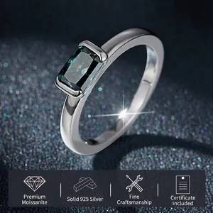 Green emerald cut moissanite ring in 925 sterling silver on a starry blue background