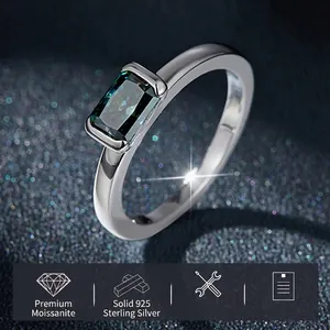 Green emerald cut moissanite ring in 925 sterling silver on a starry blue background