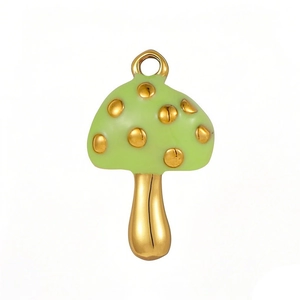 Macro detail of a polished gold mushroom pendant with light green enamel and dots