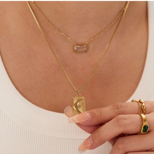 Detail of layered gold stainless steel necklace with square zircon and moon pendant