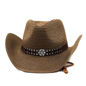 Detail of dark brown straw cowboy hat featuring leather band with metal rivets and badge
