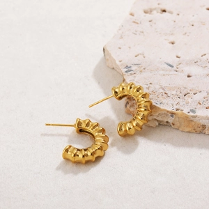 Macro shot of 18K gold plated croissant hoop earrings with textured spiral design