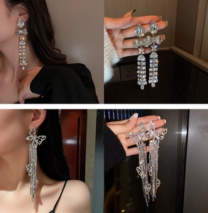 Detail shot of silver bow and butterfly drop earrings with shimmering rhinestone tassels