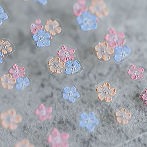 3D floral nail art stickers with embossed pink and blue petal designs on textured surface