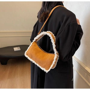 Detail shot of ginger yellow suede shoulder bag with white faux shearling trim on model