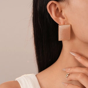 Vintage geometric resin rectangle earrings with gold trim and shimmer on a female model