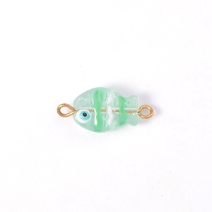 Detail of mint green fish lampwork glass bead with gold connectors for DIY jewelry