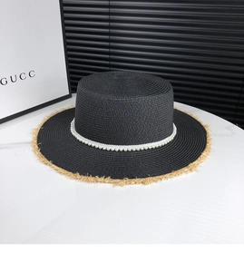 Top view of a black straw hat featuring white pearl band and beige frayed brim detailing