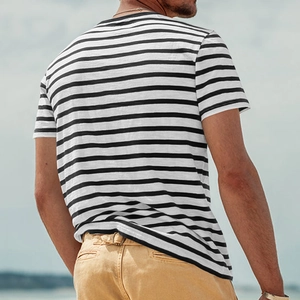 Back view of a man wearing a black and white striped short sleeve T-shirt outdoors