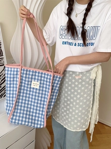 Tragetasche aus Segeltuch mit blau-weißem Karomuster, rosa Riemen und Markenetikett
