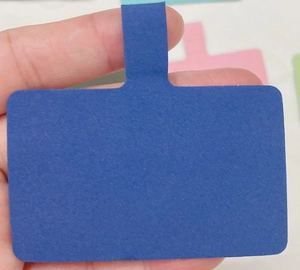Detail showing a blue rectangular universal phone tether patch made of durable felt fabric