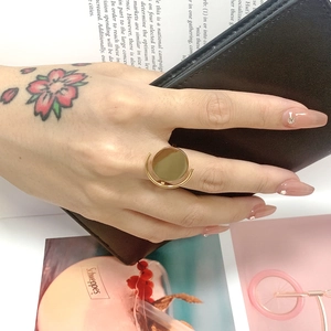 Close-up of minimalist gold geometric ring featuring a modern circular disc design