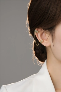 Golden double-layer chain ear cuff with zircon accents shown on a model's ear