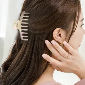 Detail of aurora pearlescent acetate hair claw clip worn by a model in hair