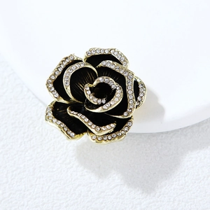 Elegante spilla a camelia con petali neri e bordi in strass placcati in oro