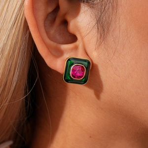 Macro d'une boucle d'oreille rétro carrée avec émail vert et pierre rose sur base dorée