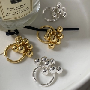 Anillos minimalistas de racimo de uvas en latón dorado y plateado sobre bandeja