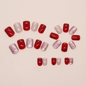 Detail of red and pink press-on nails with cat eye finish and bow nail art designs