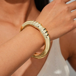 Detail shot of chunky gold textured bangle with irregular geometric wrinkled finish