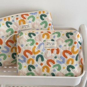 Macro shot of quilted cotton storage bag showing abstract geometric patterns and brand label