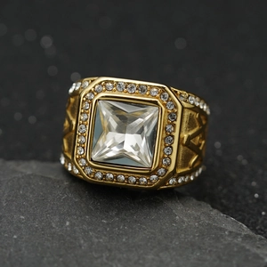 Macro detail of men's gold Masonic ring with colorful gemstone on black rock