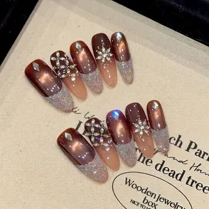 Brown cat eye press-on nails with French silver glitter and luxury rhinestone accents