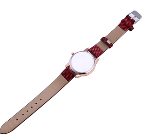 Detail view of quartz watch showing red polka dot strap and rose gold metal casing