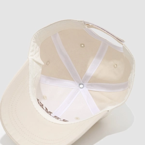 Vista interna del cappellino beige in cotone a sei pannelli con dettagli su fodera e cuciture