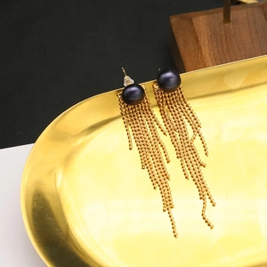 Macro detail of natural dark pearl tassel earrings with 18k gold plated finish
