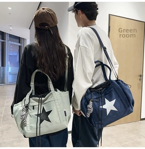 Water-resistant large tote bag with star print and checkered charm in lifestyle view