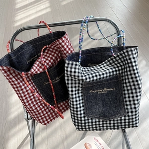 Detail of retro gingham and denim tote bags with colorful beaded shoulder straps
