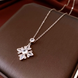 Detail of zircon flower pendant necklace in rose gold on luxury red velvet backdrop