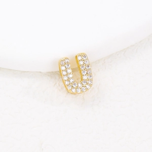 Macro shot of gold letter U pendant with micro-pave sparkling cubic zirconia stones