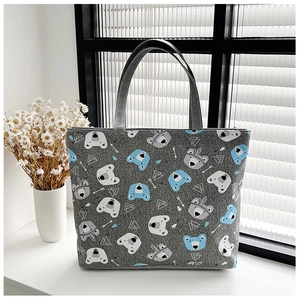 Detail view of canvas tote bag with cute bear pattern on a sunny white windowsill