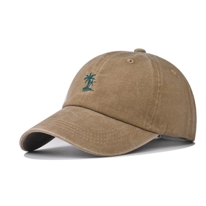 Detailed embroidery of a green coconut tree on a vintage washed khaki baseball cap