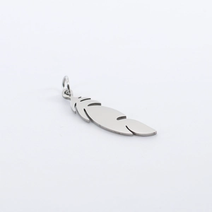 Macro shot of silver feather pendant with jump ring crafted from polished stainless steel